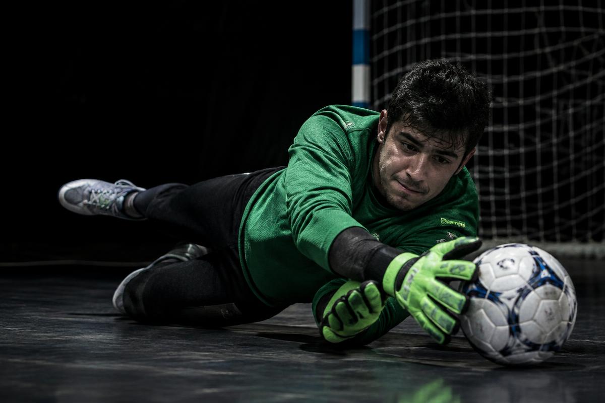 Goleiro defendendo em quadra de futsal